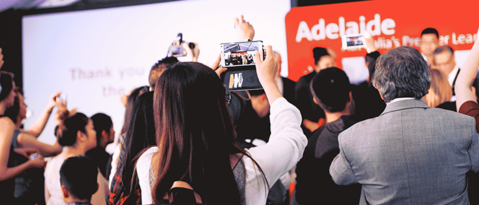 Female taking photo on smartphone at International Student Awards ceremony