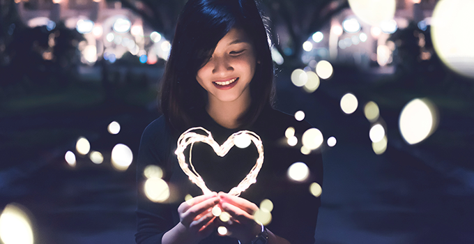 Student holding a virtual heart made of light