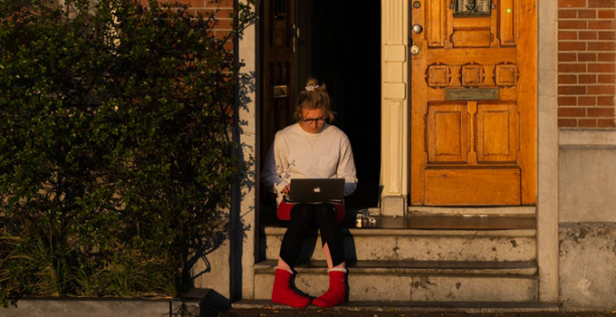 Image of a girl sitting on steps with a laptop