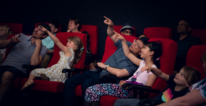 Image of people in the Adelaide Planetarium, pointing at the domed sky