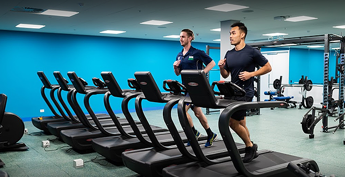 image two men each running on treadmills
