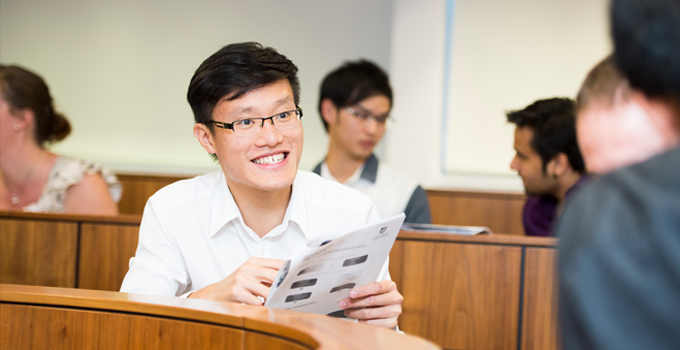 Man holding worksheet and smiling at friend