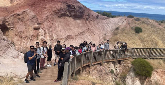 Group of students standing on glacial boardwalk trail stairs 