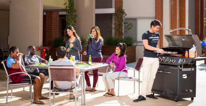 Photo of happy students having a BBQ and chatting at student accommodation