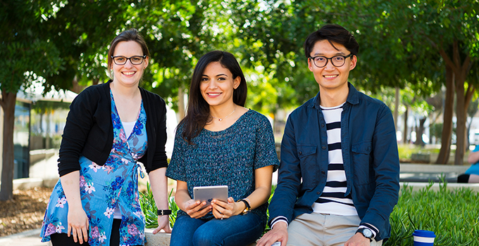 Image of two female and one male students sitting outside