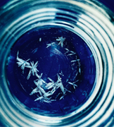 White drug crystals in a blue petri dish.