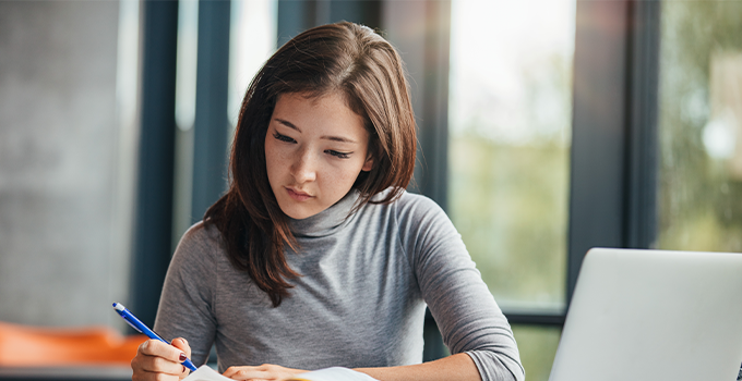 Female student concentrating while studying indoors.