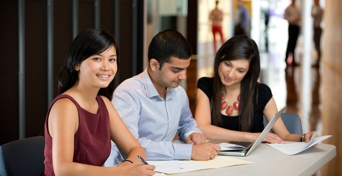 Image of two female and one male students studying together