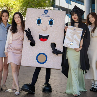 Image of Parchie with students and family during graduation