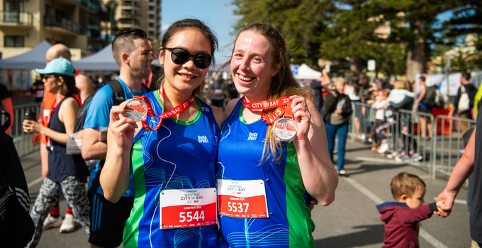 Competitors holding medals at the City-Bay fun run