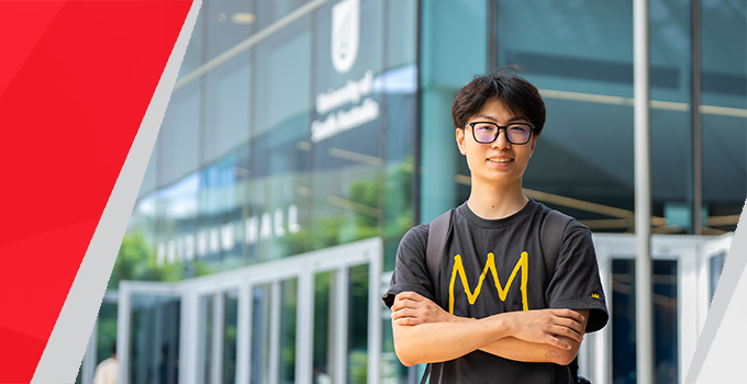 An image of a male international student standing outside Pridham Hall