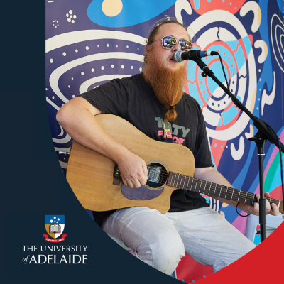 Photo of musician playing acoustic guitar live, accompanied by University of Adelaide logo.