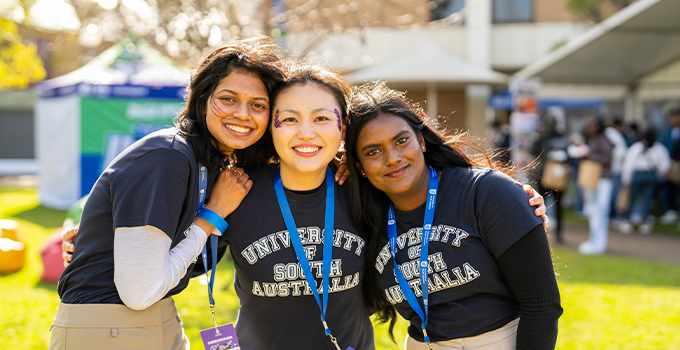 Three female UniSA student volunteers at an outdoor Mawson lakes event