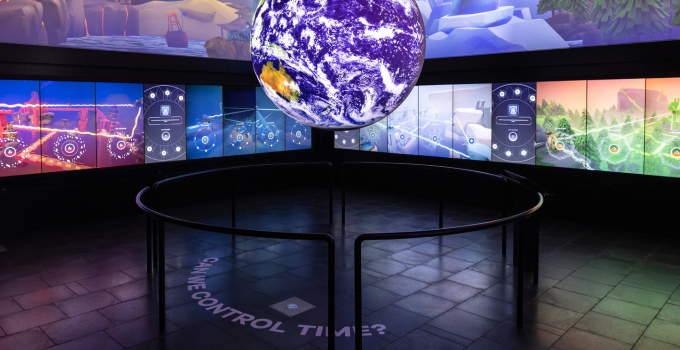 MOD. museum exhibit with globe projection, surrounded by LED screen displaying infographics.