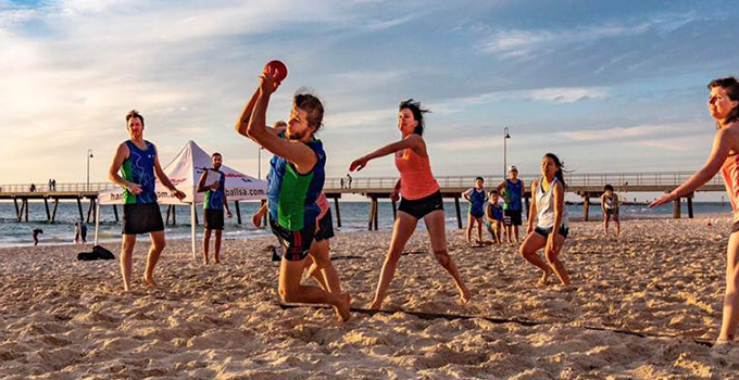 Group of students playing sport at the beach