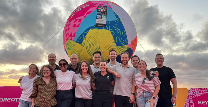 Sarah Campbell (sixth from left) and her FIFA colleagues posing for photo in front of a large multi-coloured soccer ball.