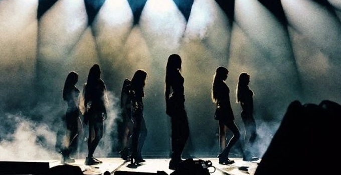 Silhouetted K-pop dancers on stage