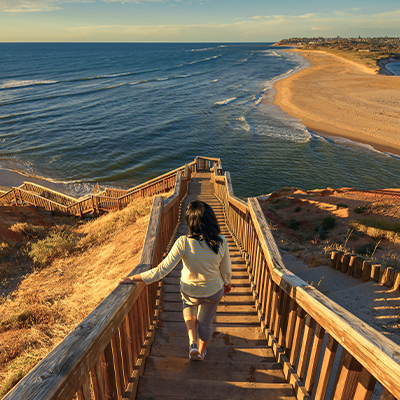 Image of a someone walking down the steps to the beach in Port Noarlunga