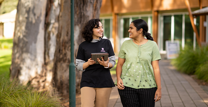 Female ASR wearing a UniSA t-shirt talking with female student at Magill campus